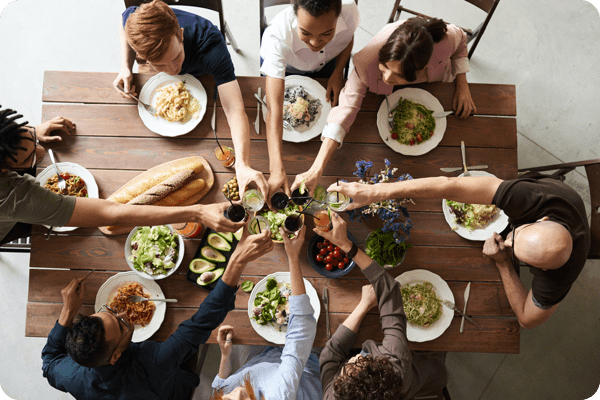 Cette photo montre des personnes partageant un repas autour d'une table